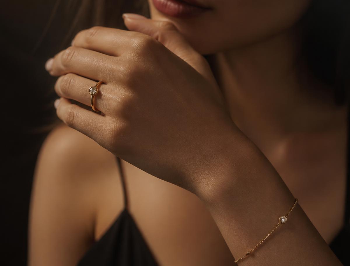 Mão feminina com anel e pulseira em ouro 18k da Kanaan Joias